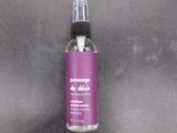 purple spray bottle on a gray surface with a black background