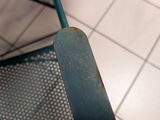 someone is holding a pair of scissors in their hand on a tiled floor