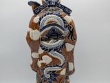 a vase with a dragon on it on a white surface