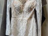 wedding dress hanging on a hanger in front of a wall