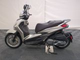 a silver and black scooter parked on a checkered floor