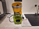 un extracteur de jus vert et jaune posé sur un plan de travail