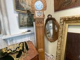 a grandfather clock in the corner of a room with pictures on the wall