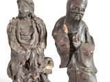two asian figurines of men and a dog on a white background