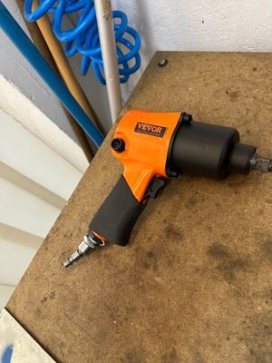 une perceuse électrique orange et noire posée sur une table