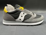 grey and yellow sneakers with white soles on a gray surface