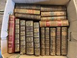 many old books in a cardboard box on the floor