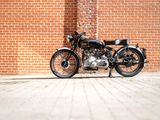a black motorcycle parked in front of a brick wall