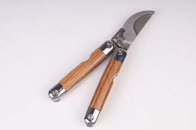 pair of garden shears with wooden handles on a white surface