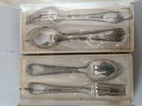 three boxed silverware items in a box on a table
