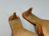 pair of women ' s brown leather slippers on a white surface