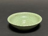 a green bowl sitting on a black surface