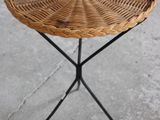 a close up of a small wicker table on a cement floor