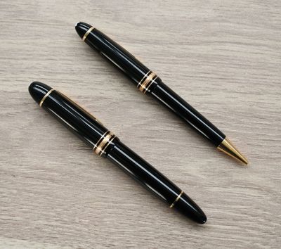 deux stylos à plume noirs et dorés posés sur une table en bois