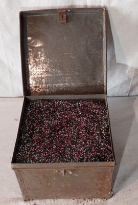 une boîte en métal contenant un tas de perles