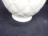 a white bowl with a pattern on it sitting on a black surface