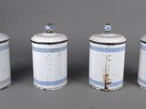 three white and blue canisters with lids on a gray surface