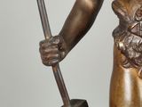 bronze statue of a woman holding a hammer and a hammer