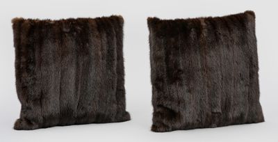 deux coussins en fourrure marron posés l'un sur l'autre