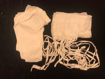 a white cloth bag and a pair of gloves on a black surface