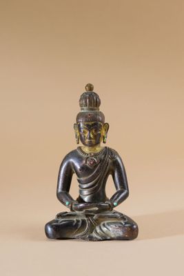 statue d'un Bouddha assis en position du lotus sur un fond beige