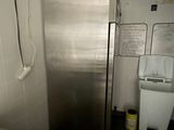 a stainless steel refrigerator in the corner of a bathroom