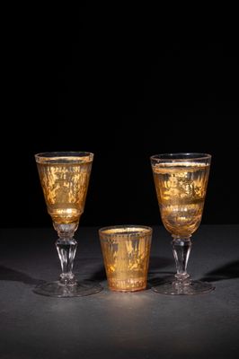 three wine glasses are sitting on a table with a black background