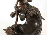 bronze statue of a woman sitting on a wave holding a fish