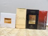 three boxes of perfume sitting on top of a wicker table
