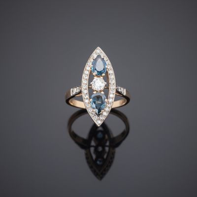 a blue and white diamond ring on a black surface