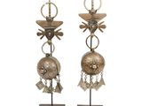 pair of silver metal earrings with bells and tassels on stands