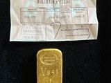 une photo d'un lingot d'or à côté d'un ticket de caisse
