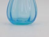a blue glass vase sitting on a white surface