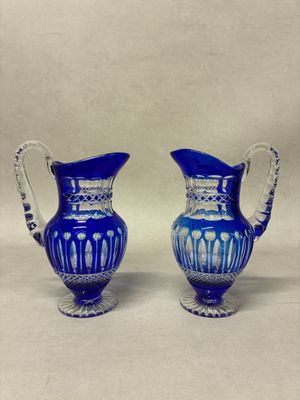 paire de vases en verre bleu avec des anses, sur fond blanc