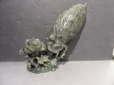 a statue of a bird with a flower on a table