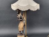 an image of a lamp with a woman holding a lamp shade on top of it