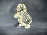 a clear glass duck with a baseball cap on it ' s head