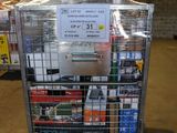 un chariot de supermarché sur lequel est accrochée une pancarte, dans un entrepôt