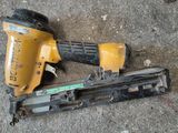un pistolet à clous et une cloueuse posés par terre