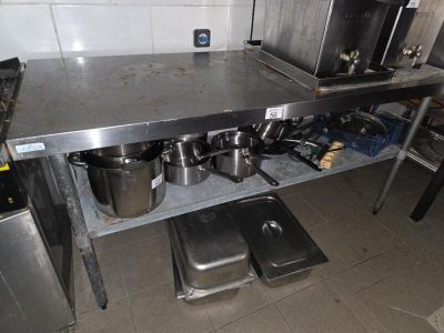 a stainless steel table with pots and pans on it