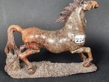 figurine of a horse running on a rock with a number 22 on it