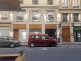 une petite voiture rouge garée devant un immeuble