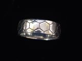 gros plan d'une bague en argent sur une surface noire