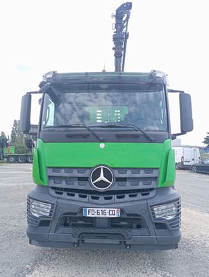 un camion Mercedes vert garé sur un parking