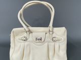 a white purse sitting on top of a black table