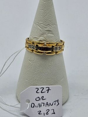 two gold rings with diamonds on a white cone with a price tag