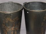 two metal buckets sitting next to each other on a table