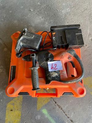 an orange tool box with a drill and two batteries on it