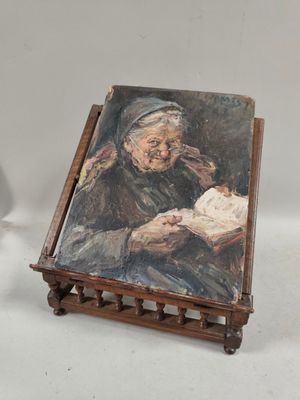 tableau représentant une vieille femme en train de lire un livre sur un chevalet en bois