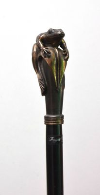 une statue représentant une main tenant une canne sur laquelle est perché un oiseau